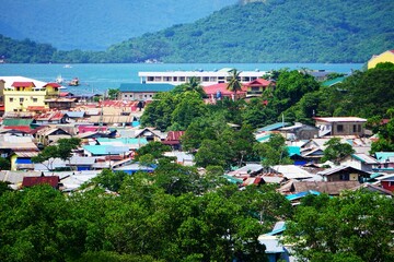 Wioska rybacka na wodzie. Domy usytuowane na wodzie. Niewielkie domki na wybrzeżu, łodzie rybackie, panorama na ocean, dzika natura i góry. Życie na Filipinach na przepięknej wyspie Palawan. © Adam