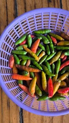 Chili peppers in a purple basket on a wooden table
