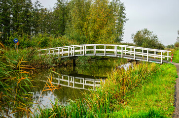 Simple wooden footbridge across a canal near Schalkwijk, The Netherlands, in autumn