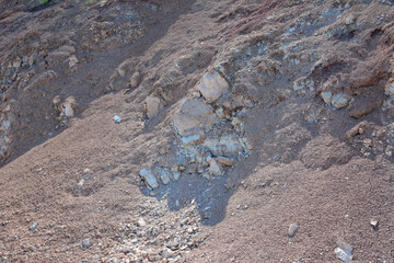 a rock formation is in the dirt with a small rock in the middle 