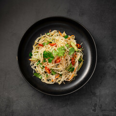 Salad with sprouts, celery and greens on a black background, top view