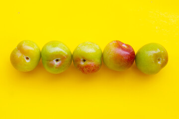 Fresh green plum on yellow background