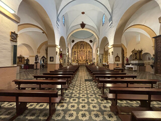 Ornate church interior, altar, pews, religious art.