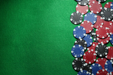 Poker chips on green table, flat lay. Space for text