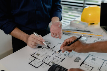 an architect and an engineer are discussing about big projects that they have to take responsibility for together, engineer and his assistant are meeting about the first draft of blueprint