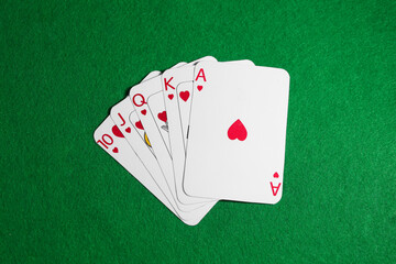 Poker game. Playing cards on green table, top view