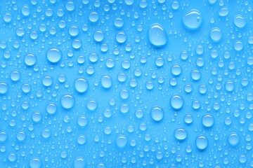 Water drops on blue background, top view