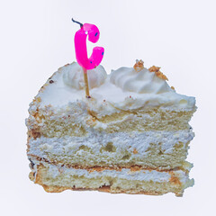 A piece of sponge cake with extinguished candles in the shape of the letter C close-up.