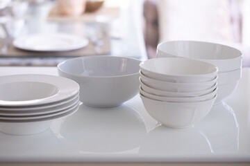 Set of clean dishes on white marble table.