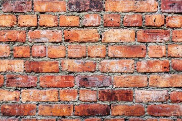 Fototapeta premium A textured wall made of red bricks with mortar in between.