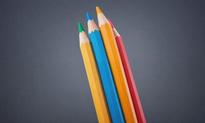 Fototapeta premium Four colored pencils are lined up against a gray background