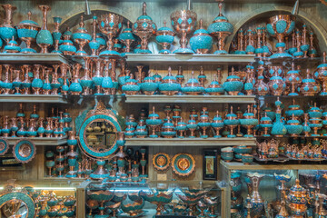 A shelf filled with colorful plates and vases of various shapes, Shiraz, Iran