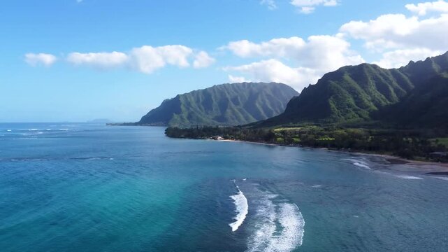 Incredible aerial view dramatic mountains blue turquoise ocean water at Kualoa Ranch park, Punaluu beach park. Coast of Oahu island Hawaii USA. Beautiful nature view mountain peaks with tropical beach