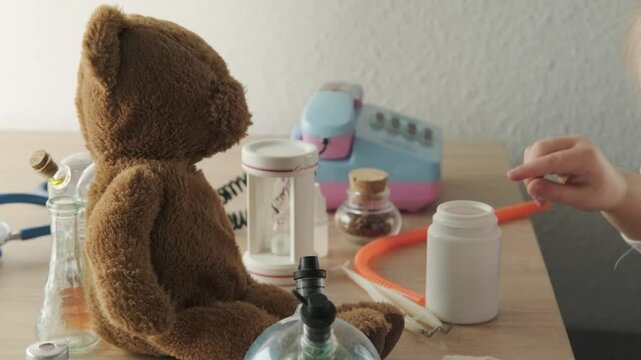 close-up teddy bear, child, girl 3 years old treats little patient, favorite toy, first friend concept, happy childhood, first impressions, medical professional support, health insurance and care