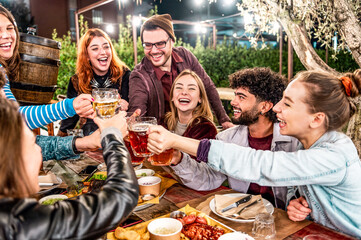 Young friends dining and having fun drinking beer together at barbecue backyard home party - Happy...