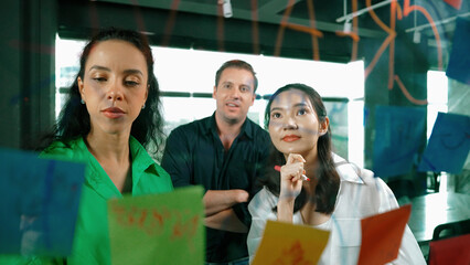 Portrait of professional diverse business team brainstorming marketing idea on colorful sticky...
