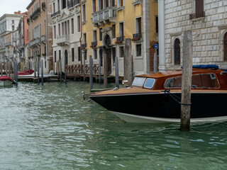 Fototapeta premium Close-up of a luxury wooden water taxi docked along a Venetian canal, showcasing elegant design and craftsmanship. Iconic Venice water transport scene.