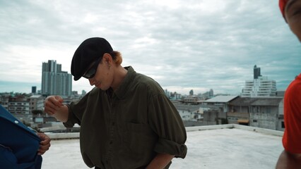 Closeup image of profession hipster dancing break dance at rooftop with multicultural friends. Break dancer practicing street dance while surrounded by partners. Hip-hop. Outdoor sport 2024. Hiphop.