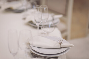 on the festive banquet table are plates with napkins, glasses and cutlery. festive table with empty plates and glasses at restaurant