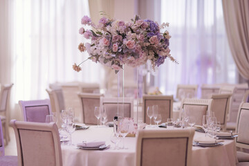 festive wedding decoration. Beautiful fresh flowers in glass vase on dining table on wedding day. luxury wedding decor with flowers and glass vases with jewels on round tables. expensive catering.