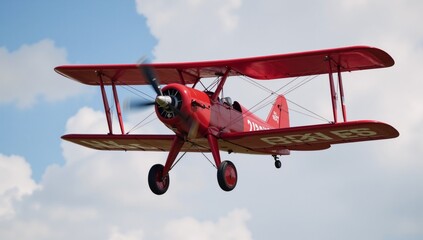 A red biplane soars through cloudy skies with its propeller rotating