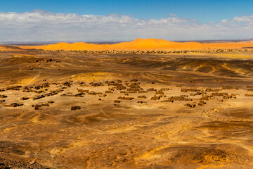 View of the Black Desert and ruined old houses near an abandoned mine.   Merzouga, Erg Chebbi, Morocco.
