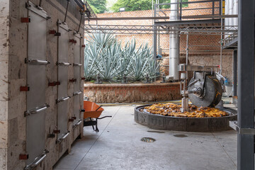 Agaves, hornos y taona en la fábrica de tequila de Jalisco México.