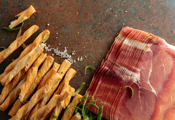 Prosciutto with bread sticks and rosemary.