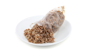 Open transparent plastic bag with boiled buckwheat in plate isolated on a white background. Boil in bag buckwheat groats.