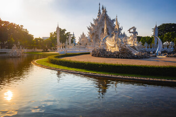 Fototapeta premium Beautiful and amazing white temple at Wat Rong Khun at sunset time Chiang Rai, Thailand It is a tourist destination. Landmark of Chiang Rai