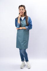Young female barista wearing apron standing, holding hand on her chin, full length portrait on a...