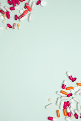 Concept of medicine, healthcare, and pharmaceutical industry. Various colorful pills and capsules scattered on a light blue background