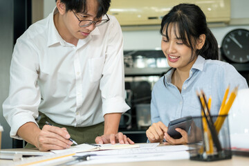 Engineers looking and discussing over blueprints on desk.