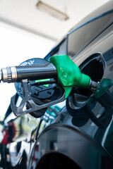 Close up of hand holding green fuel nozzle