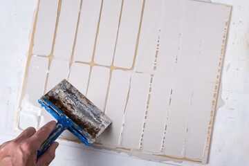Filling and leveling of decorative brick molds with spatula.