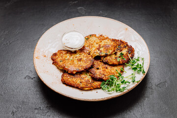 Crispy potato pancakes with sour cream and fresh greens, perfect as a savory side or appetizer