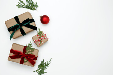 Wrapped Christmas gifts with green thuja branches creating a festive, natural holiday scene