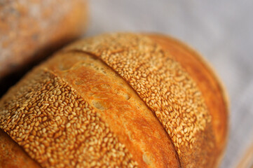 Closeup photo of crust with sesame seeds of home baked bread