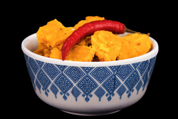 The Gujarati Kathiyawadi Spicy Dhokali Sabji with red chilli on the top, beautifully positioned in a bowl, complemented by a bold black background that emphasizes its features