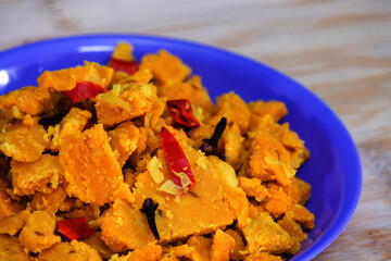 Side view of Gujarati Kathiyawadi Spicy Dhokali pieces Sabji, highlights the blue dish's distinctive features