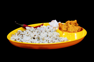 Side view of Gujarati Kathiyawadi Spicy Dhokali Sabji with khichdi and red chili, on yellow dish prominently, set against a black background
