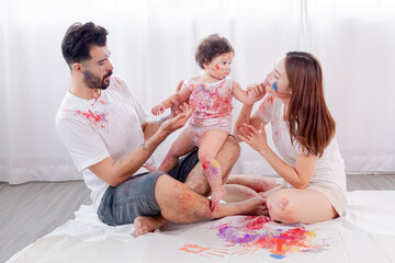 Naughty multicultural family with little toddler having fun laughing playing together at home,...