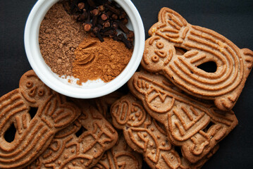 Christmas cinnamon cookies on a red background, decorated with pine branches and glowing candles.