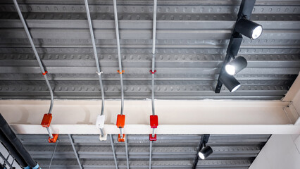 Cable conduit and junction box for electrical wiring system with exhibition lamp and plumbing pipeline on ceiling in modern building. Pipe and fitting equipment for power, lighting and pumping systems