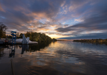 Fototapeta premium The water is calm and the sky is a beautiful orange and pink color