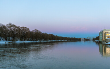 A calm river with a bridge in the background