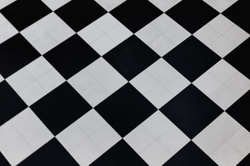 Classic black and white checkered floor tiles in diagonal pattern. Abstract geometric design creating a timeless contrast in modern interior flooring.
