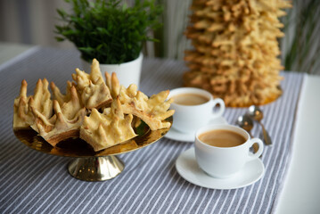 Bankuchenas - traditional regional cake from Lithuania. Delicious tree cake is prepared by hand, egg layers are baked by open fire. Cup of tea and a slice of the cake on wooden background