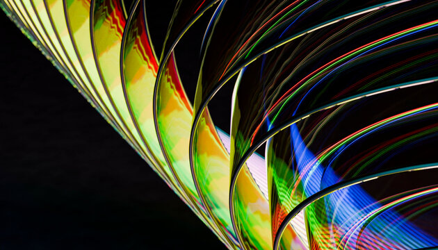 Close-up of colorful refracted light patterns on a curved surface against a dark background.