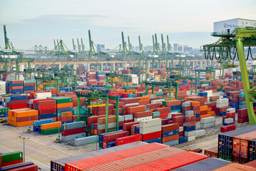 Aerial view of a busy cargo terminal with numerous colorful shipping containers stacked and ready for transport, Singapore